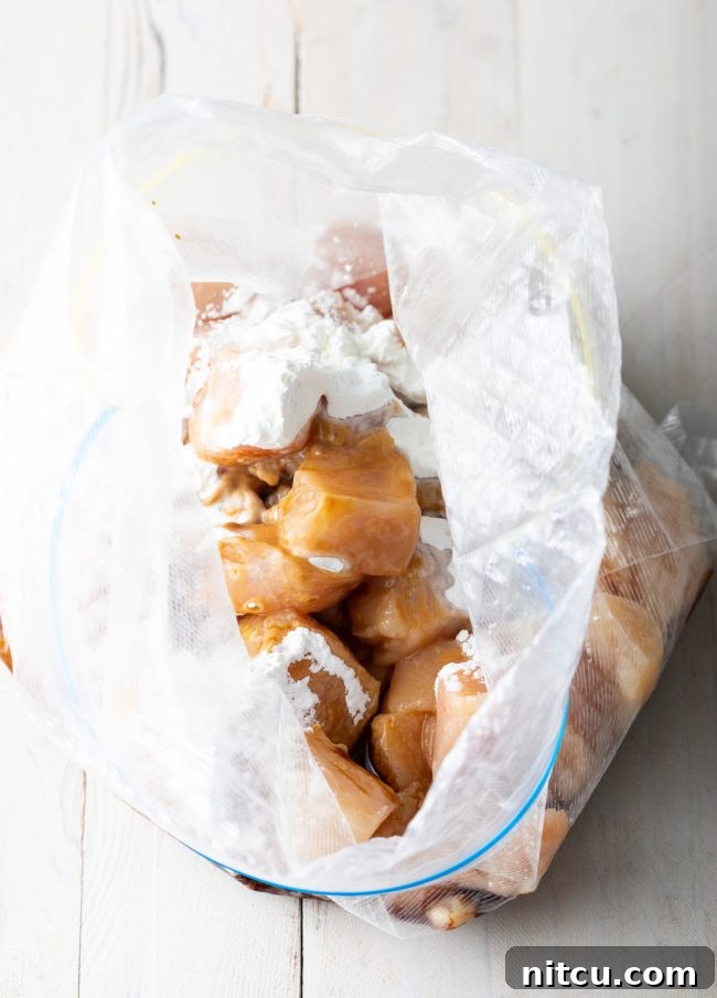 Plastic ziploc bag with pieces of chopped chicken and cornstarch.