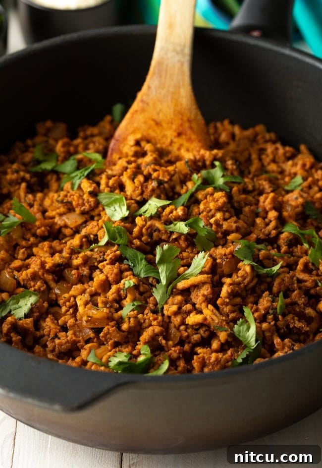 Fresh cilantro on turkey taco meat simmering in a skillet