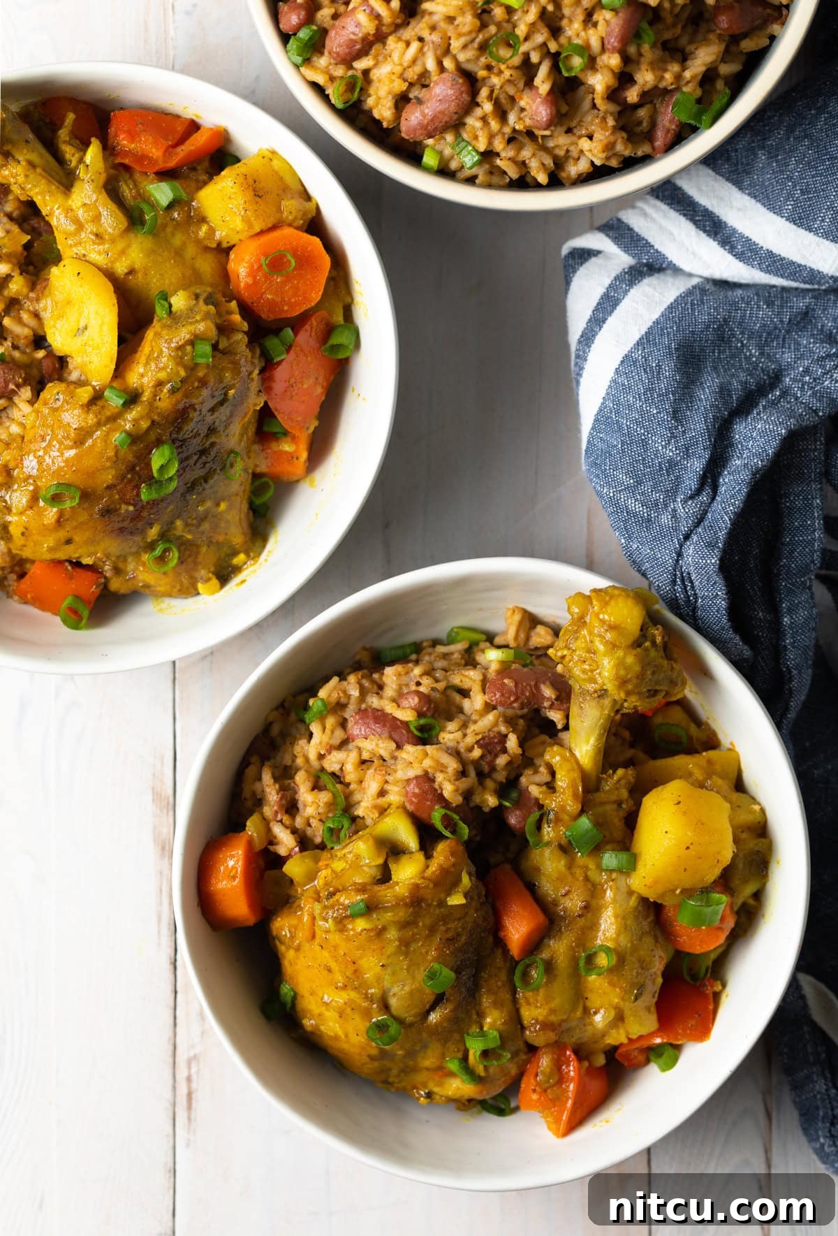 Bowls of yellow chicken curry with vegetables, ready to be served.