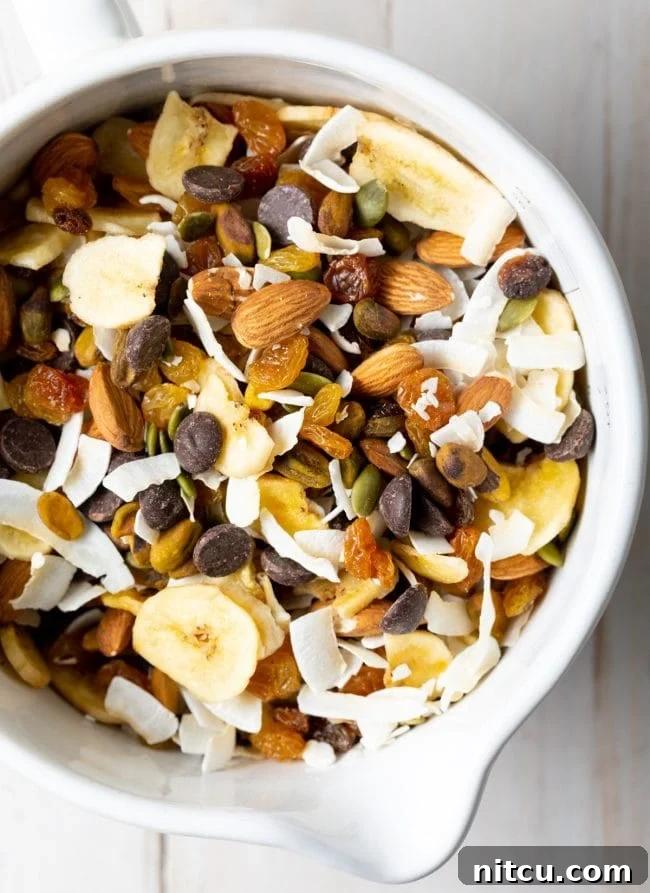 Healthy homemade trail mix with seeds and nuts in a white bowl, perfect for a balanced snack.