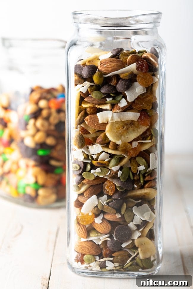 Homemade trail mix recipe with banana chips, coconut, nuts, and seeds in a beautiful glass jar, ready for sharing or snacking.