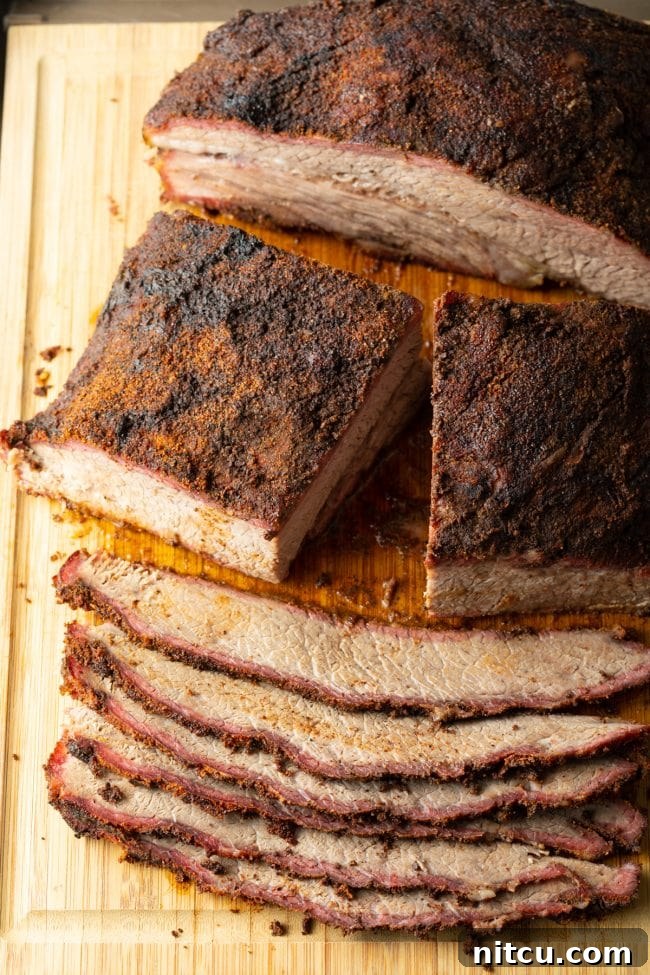 A sharp knife slicing through perfectly rested beef brisket on a cutting board, revealing the tender interior.