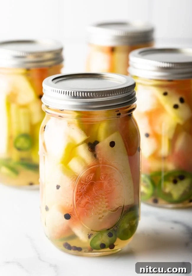 Pickled watermelon rinds in glass jars.