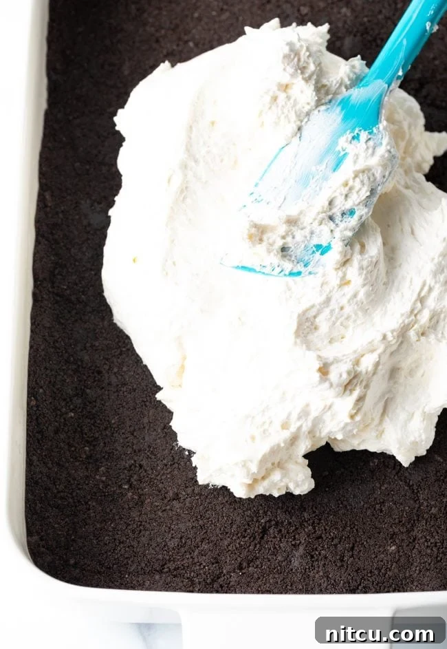 Folding Cool Whip into the cream cheese mixture with a spatula.