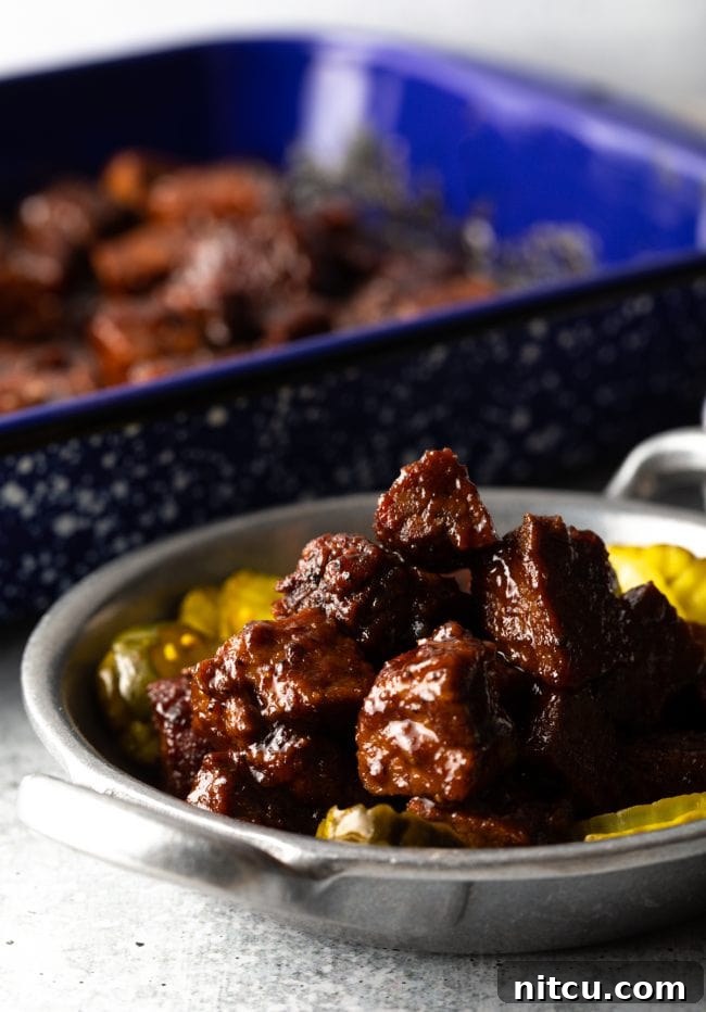 Juicy Brisket Burnt Ends tossed in a rich BBQ sauce, served with artisan bread and sweet butter pickles.