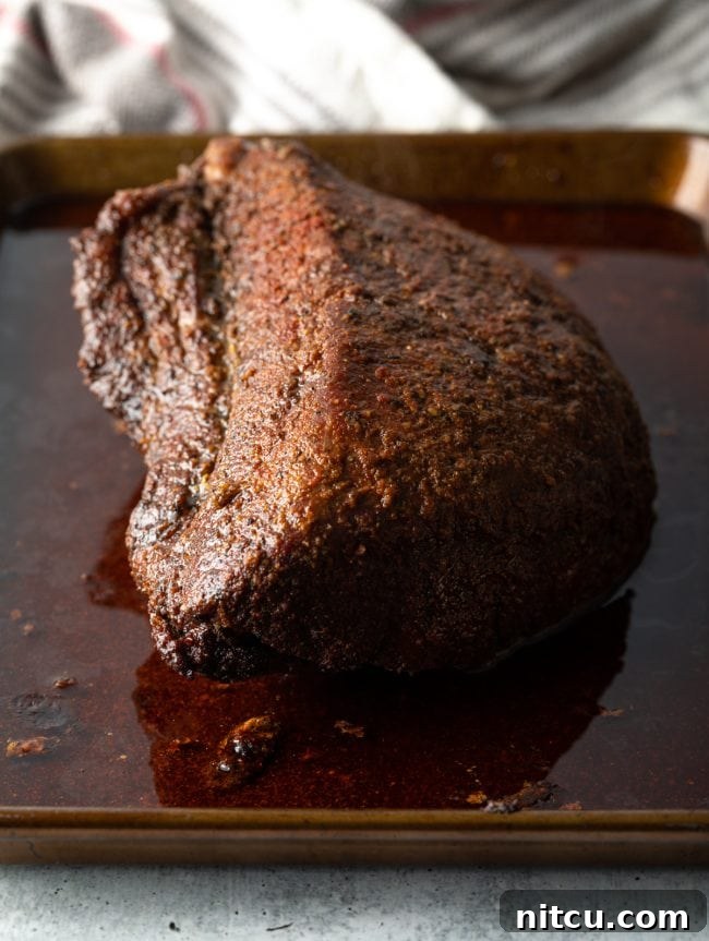 Perfectly smoked beef brisket on a baking sheet, ready for the next step of making burnt ends.