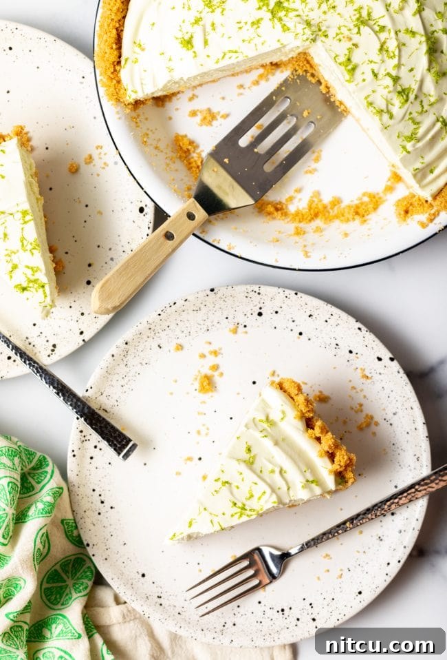 An overhead view of several perfectly cut slices of icebox lime pie arranged artfully on plates, highlighting the creamy filling and crisp crust.