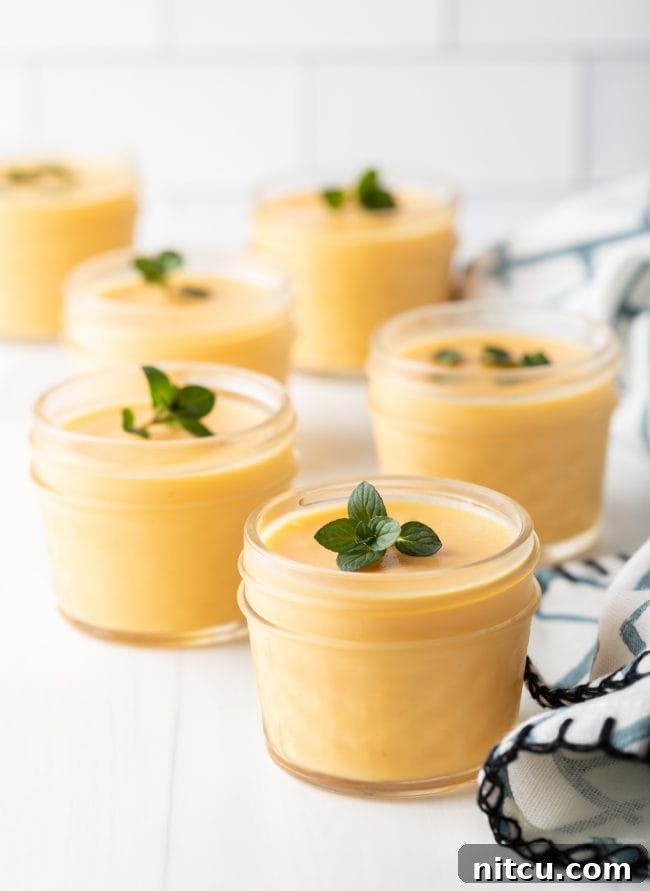 lined up cups of dairy free mango pudding with mint garnishes