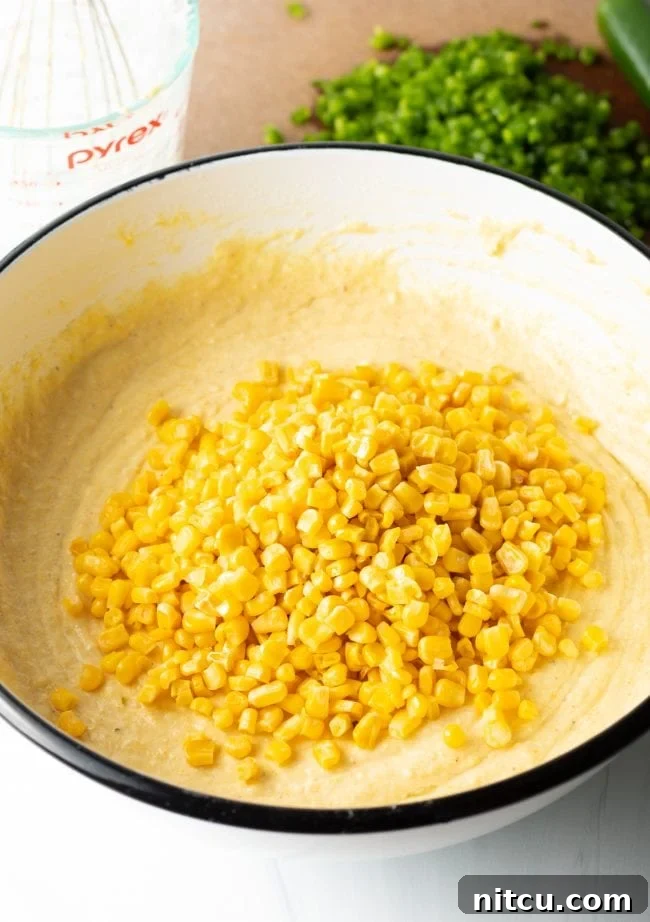 Mixing buttermilk, eggs, and melted butter into the dry cornbread ingredients.