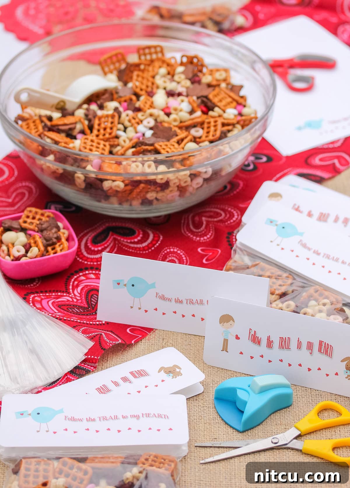 trail mix in a big bowl with little gift bags and tags next to it.