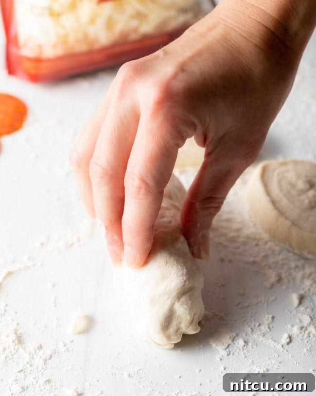Hand rolling a pepperoni roll.
