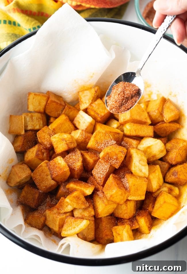 Tossing the freshly fried Papas Bravas in Mexican spices in a bowl