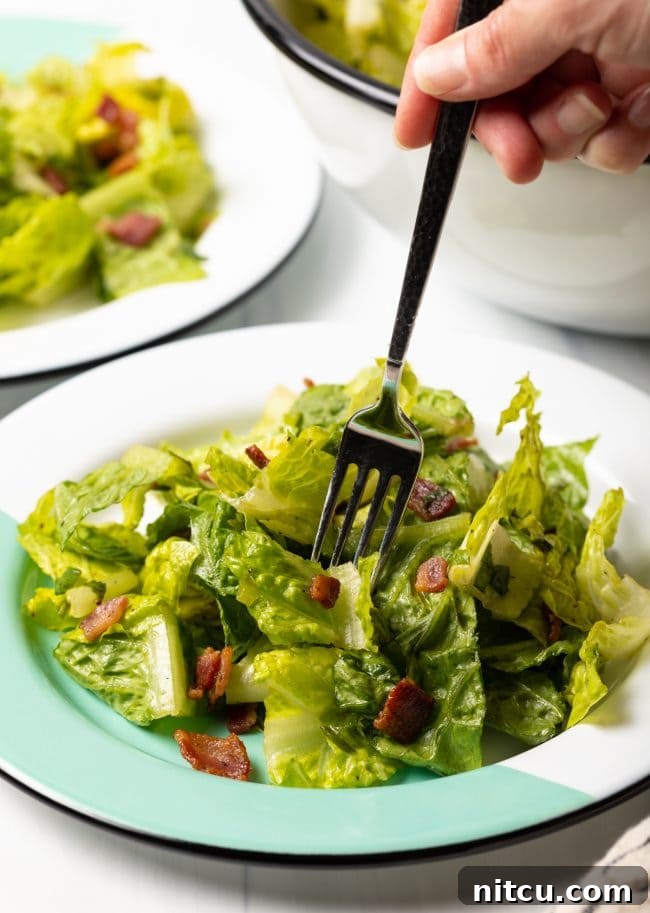 fork taking a bite of wilted lettuce salad recipe