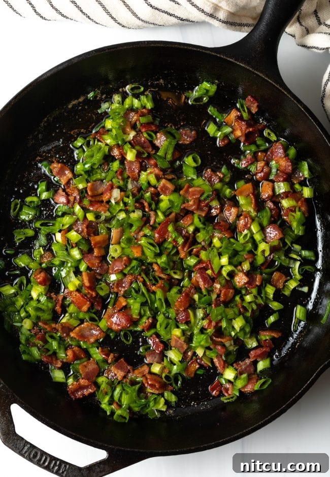 skillet with cooked chopped bacon and sliced green onions
