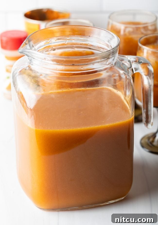 glass pitcher half filled with orange liquid