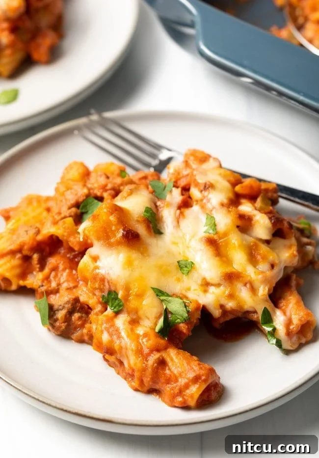 Close-up of a generous serving of Baked Rigatoni Bolognese on a plate, showcasing the rich sauce, tender pasta, and melted cheese.