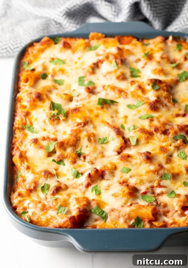 A stunning finished casserole of easy oven-baked rigatoni bolognese, garnished with vibrant fresh basil, ready to be served.