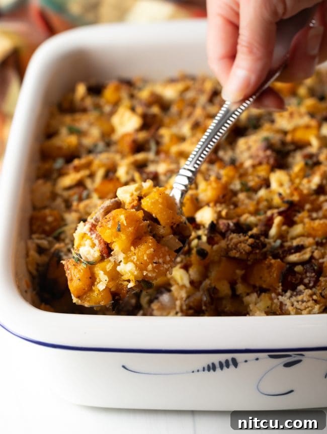 Savory Butternut Squash Casserole -
spoon scooping a helping of squash stuffing from a baking dish