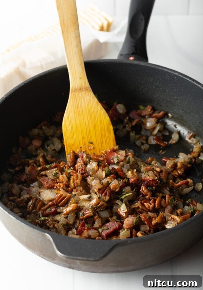 cooking bacon with aromatics in a cast iron skillet with wooden spoon