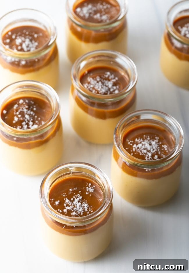 Italian Dessert Recipes - top side view several glass jars with homemade butterscotch budino topped with caramel and salt