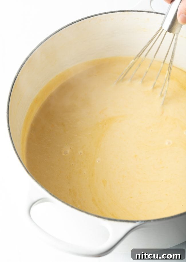 whisking egg yolks and half and half into the mixture