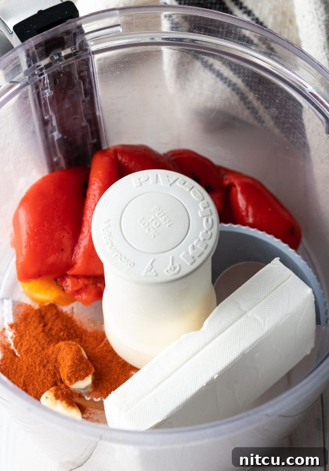 Roasted red peppers, cream cheese and spices in a food processor. 
