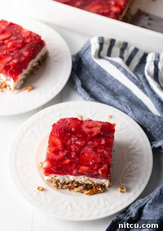 Top view of strawberry jello salad with a thick cream cheese layer and a golden pretzel crust.