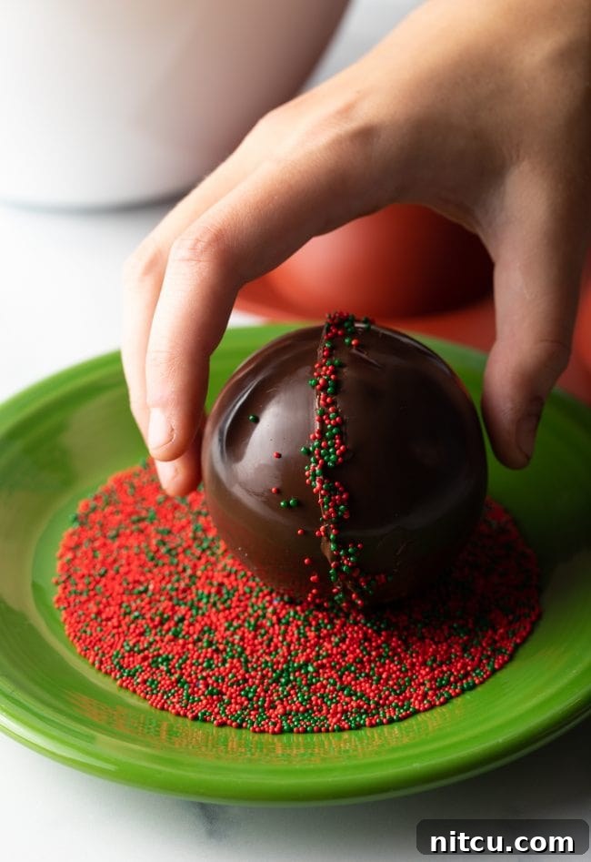 Hand rolling chocolate spheres into sprinkles.