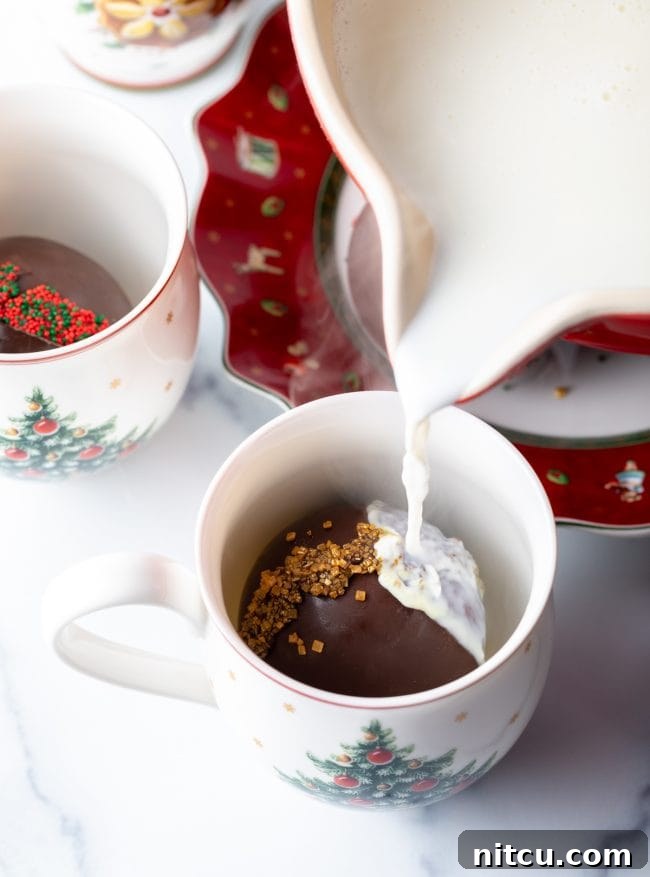 Hot milk being poured over hot chocolate bomb.