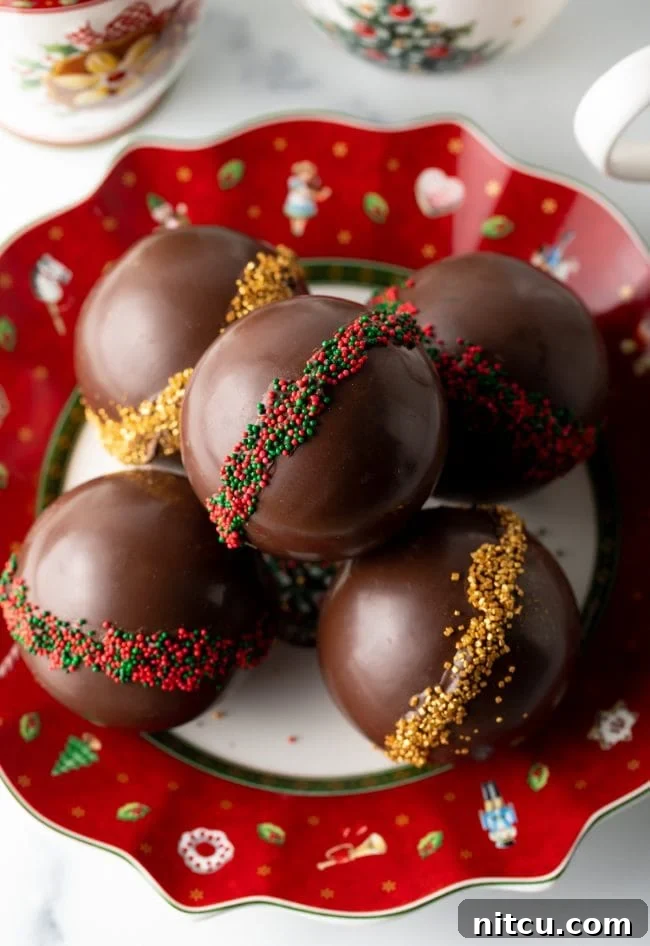 Top view decorated cocoa bombs stacked on a Christmas plate