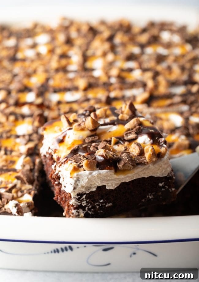 A side view captures a metal spatula gently lifting a perfect piece of Better Than Sex Cake out of the baking pan, highlighting its distinct layers and inviting texture.