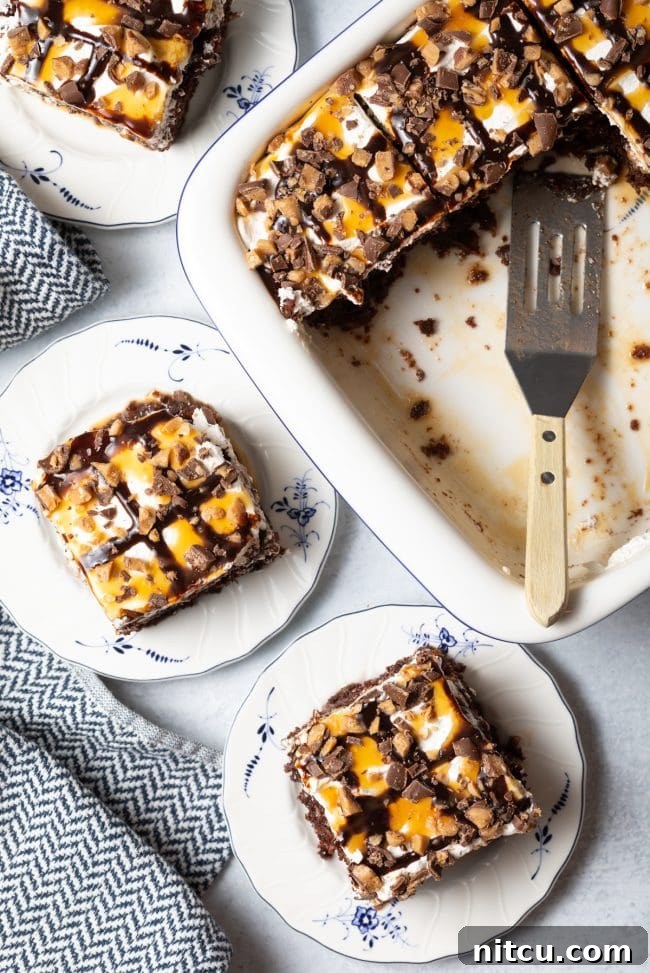 Top-down view of two slices of BTS cake served on elegant white and blue plates, with the remaining cake and a spatula positioned to the side, showcasing its delicious layers and perfect presentation.