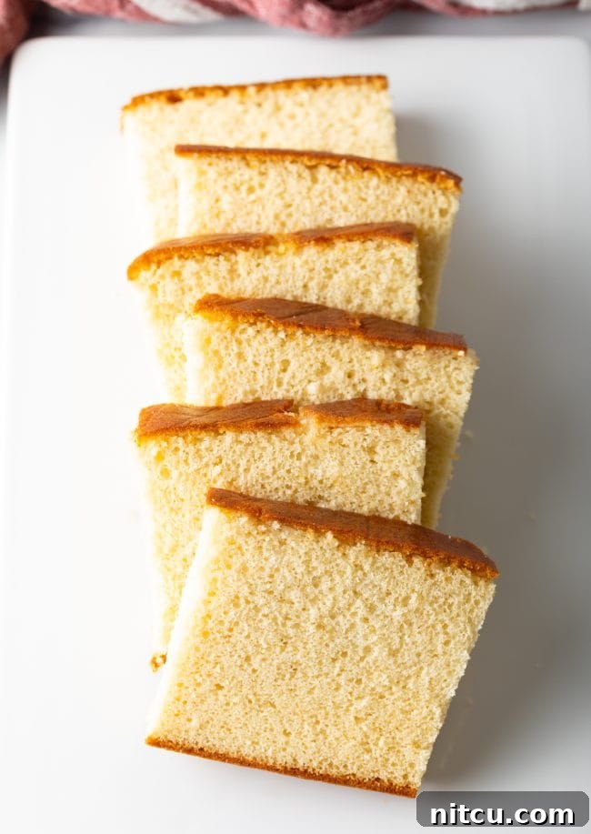 Slices of Japanese Sponge Cake lined up on a white plate.