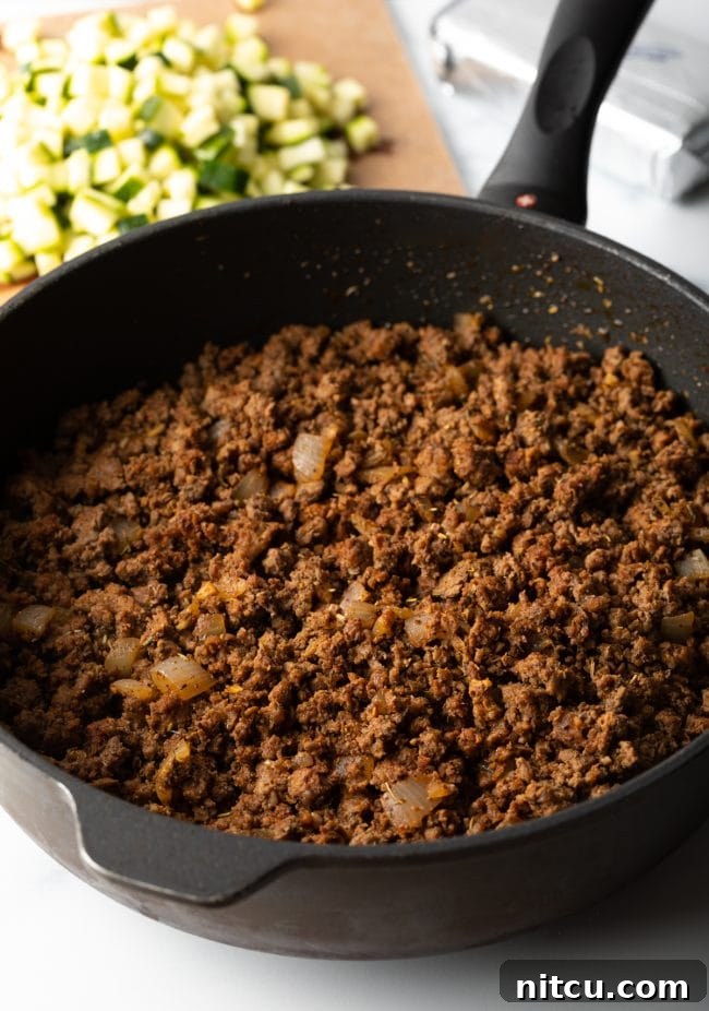 Skillet of browned crumbled ground beef.