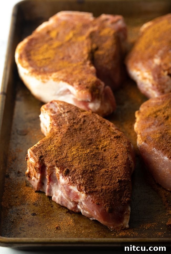 seasoned pork chops on a baking pan