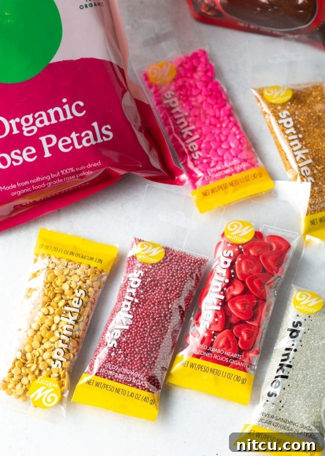 A vibrant assortment of colorful sprinkles in various shapes and textures are neatly arranged on a clean white surface, ready for creative decoration.