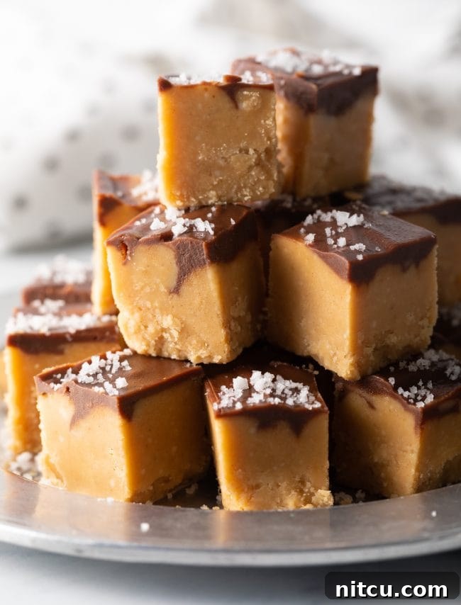 Close-up view of stacked pieces of chocolate peanut butter fudge, showing the creamy texture and chocolate swirl.