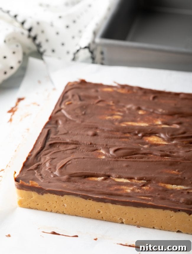 Chilled Chocolate Peanut Butter Candy square, still on parchment paper, ready to be cut into individual pieces.