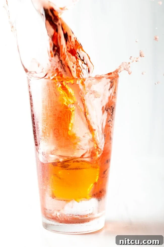 Closeup of a shot of red bull splashing into a Vegas Bomb glass.