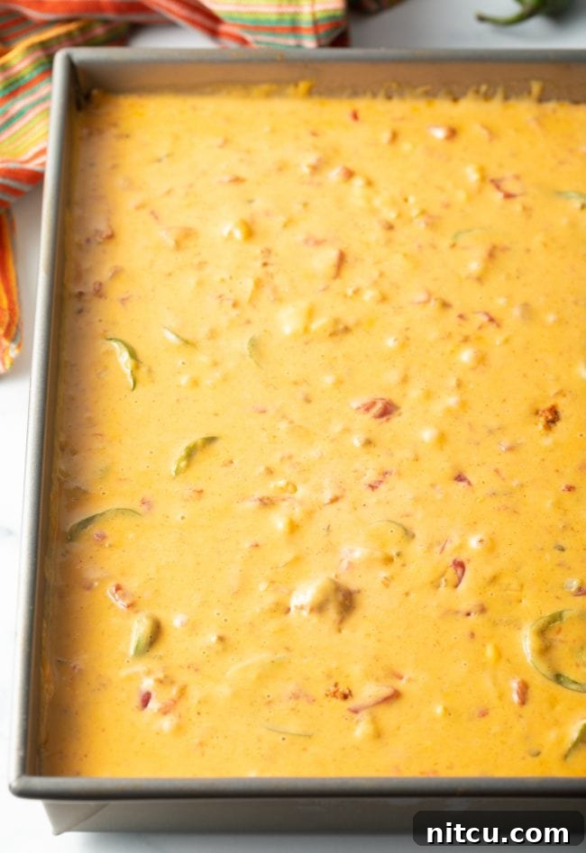 Top view of a bubbling smoked queso chorizo dip presented in a rustic metal pan, ready to be enjoyed.