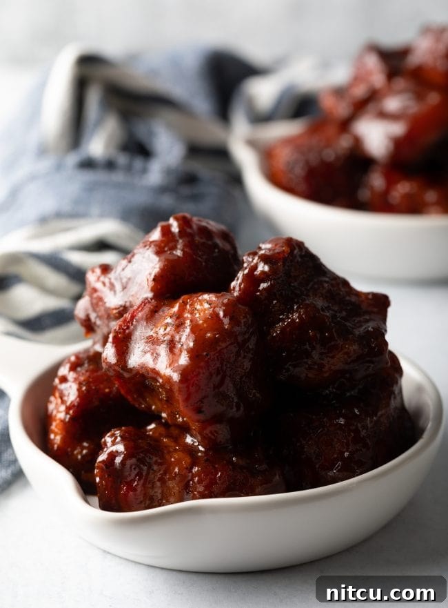 Smoked Pork Belly Burnt Ends - Tender, flavorful, meaty and utterly mouthwatering BBQ pork belly burnt ends are an absolute dream. They're tossed with a classic brown sugar spice rub, slow smoked, and tossed with tangy barbecue sauce. Then serve warm with your favorite southern side dishes, like macaroni or potato salad. This easy recipe can be made in a smoker or oven! | A Spicy Perspective