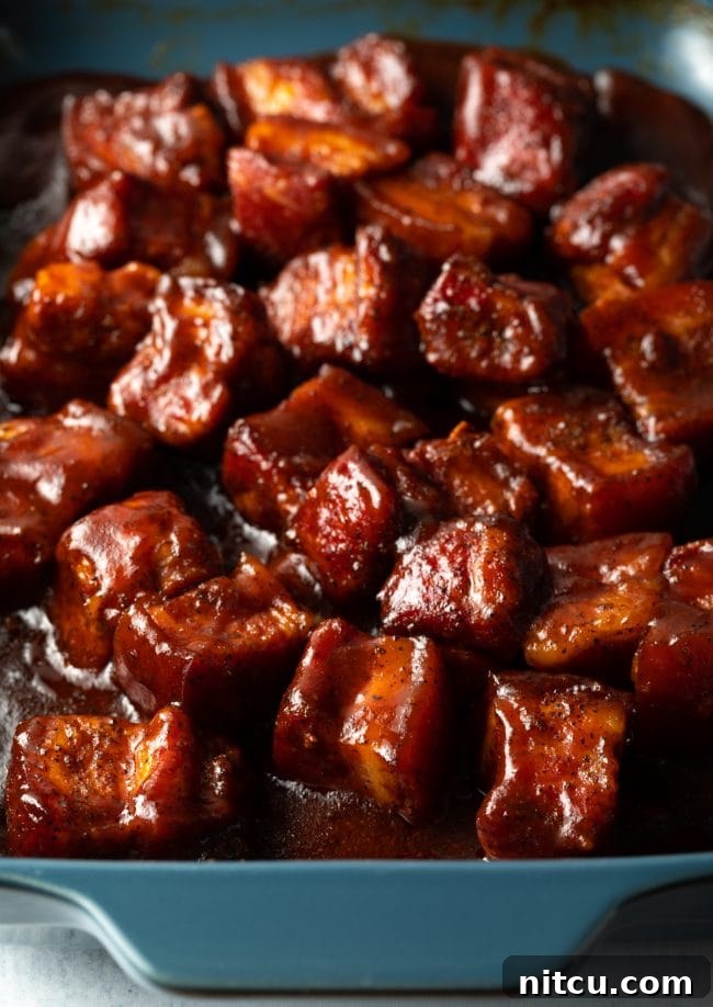 A vibrant platter of smoked pork belly burnt ends served with Southern side dishes, ready for a feast.