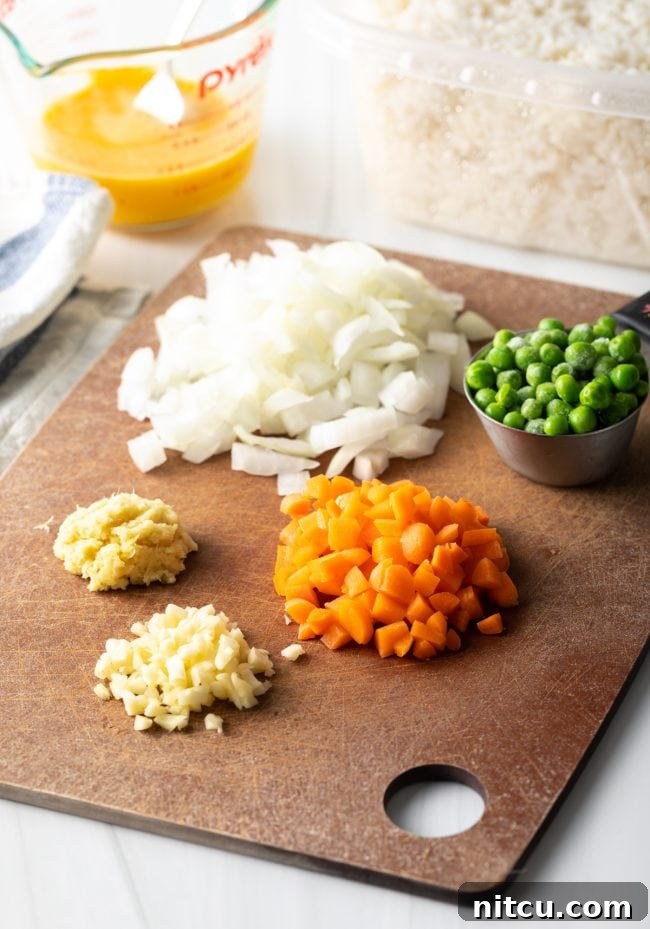 Ingredients for fried rice neatly arranged on a cutting board, prepped and ready.