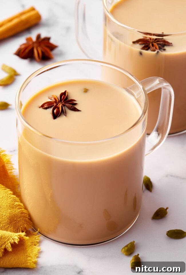 Graphic with text 'How to make Indian chai tea' featuring a photo of hot chai latte in a clear mug, garnished with spices.