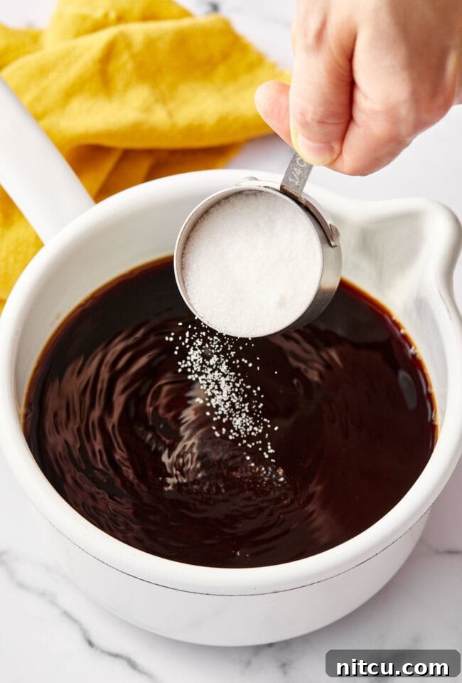 Creamy milk being gently poured into a pot of concentrated chai tea, preparing for the final blend into a smooth latte.