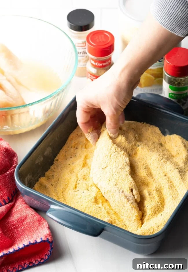 Fish fillets being dipped into a bowl of cold water.