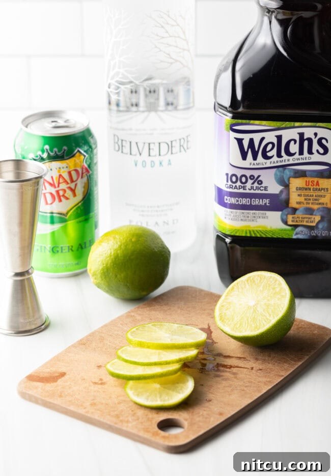 A freshly halved lime on a wooden cutting board, with one half already thinly sliced for garnish.
