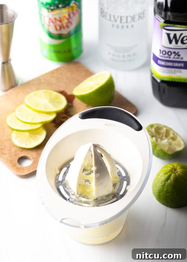 A hand-held juicer extracting fresh lime juice from a halved lime.