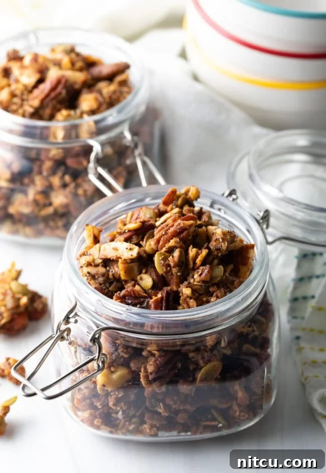 Open glass jar brimming with homemade keto nut granola, showcasing its golden, crunchy texture.