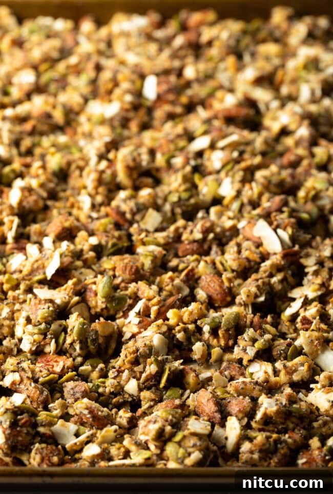 Baked keto granola on a baking sheet, golden and clumpy.